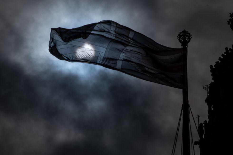 10: A partial solar eclipse is seen behind a Union Jack flag at the Houses of Parliament