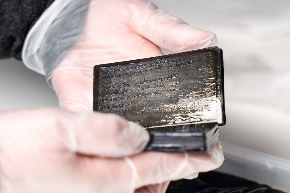 13th to 14th century preserved notebook found in medieval toilet held in hands