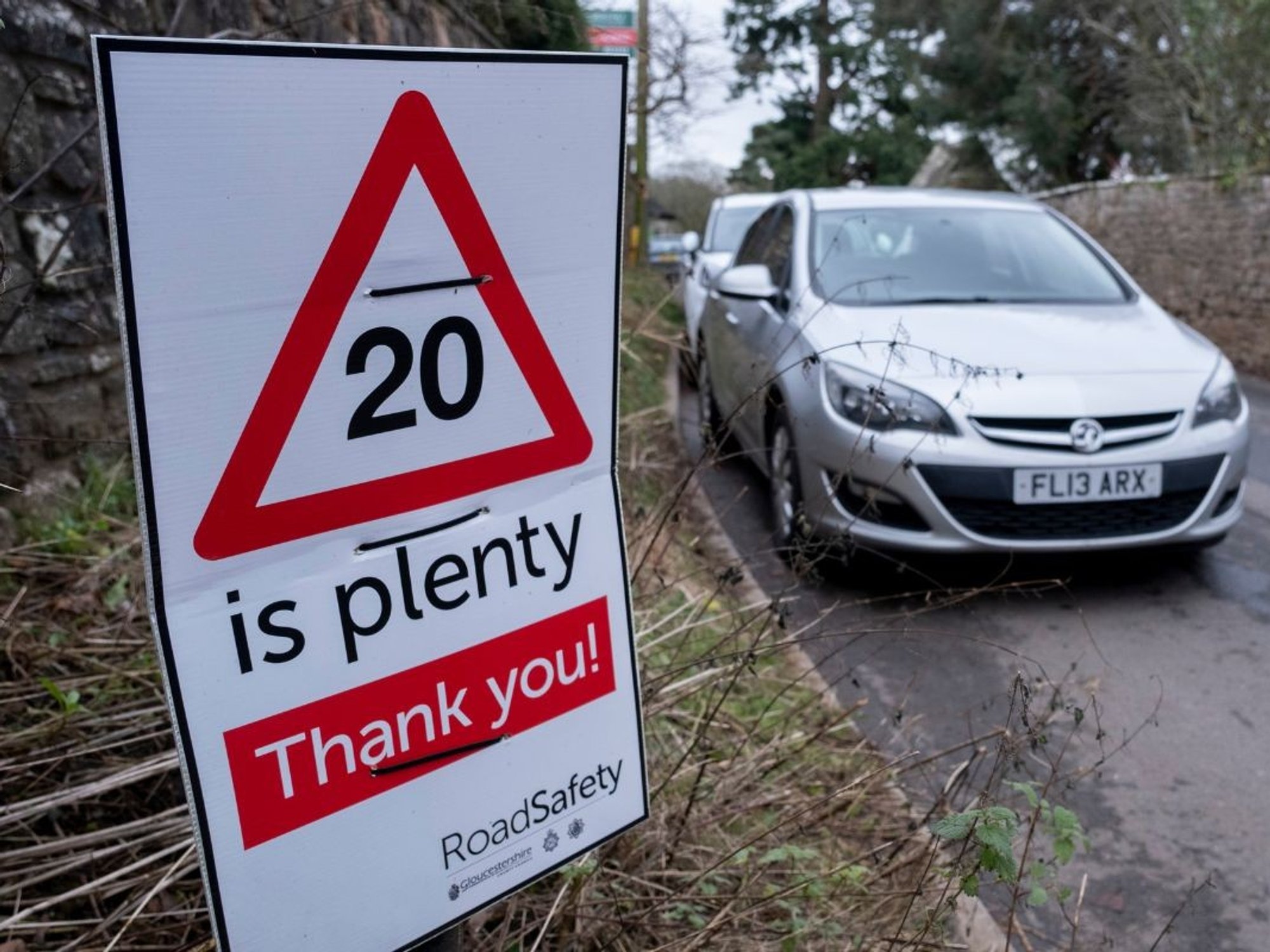 20mph speed limit sign with a car driving in the background