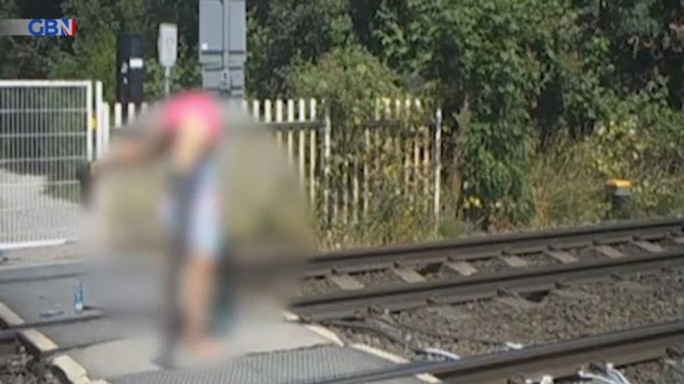Shocking moment teenagers caught on CCTV doing handstands at level crossing