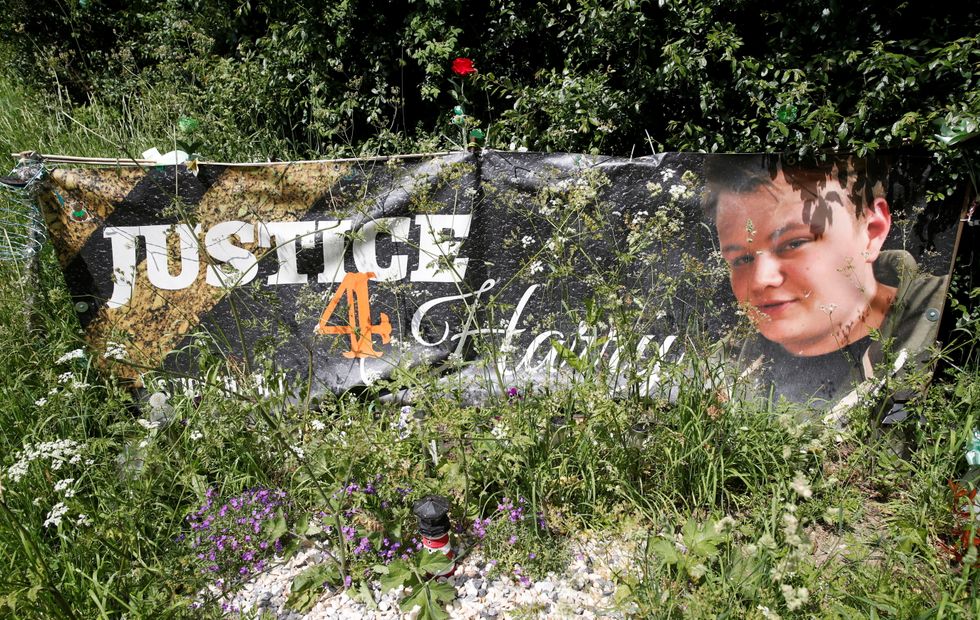 A banner and a memorial area for British teenager Harry Dunn who died in a road traffic collision is pictured near to the entrance of RAF Croughton, in Croughton, near Brackley, Britain June 11, 2021. REUTERS/Andrew Boyers