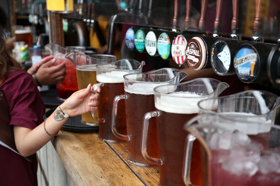 A bar worker pours jugs of beer Vinegar Yard.