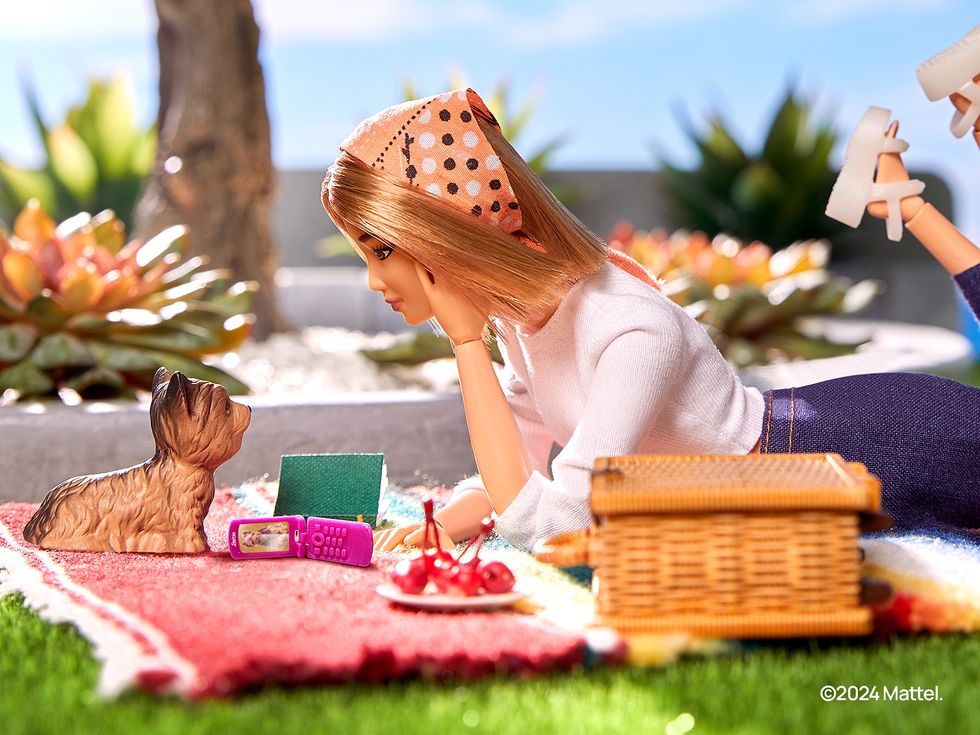 a barbie doll is pictured with the trademark pink flip phone
