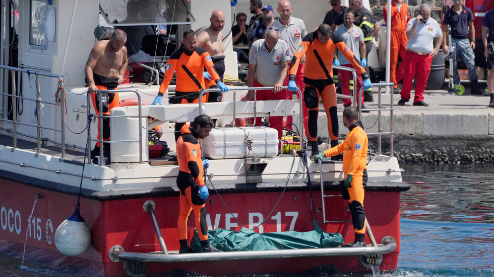 A body bag is brought ashore at the harbour in Porticello by rescue workers on the fifth day of the search and recovery operation for the Bayesian