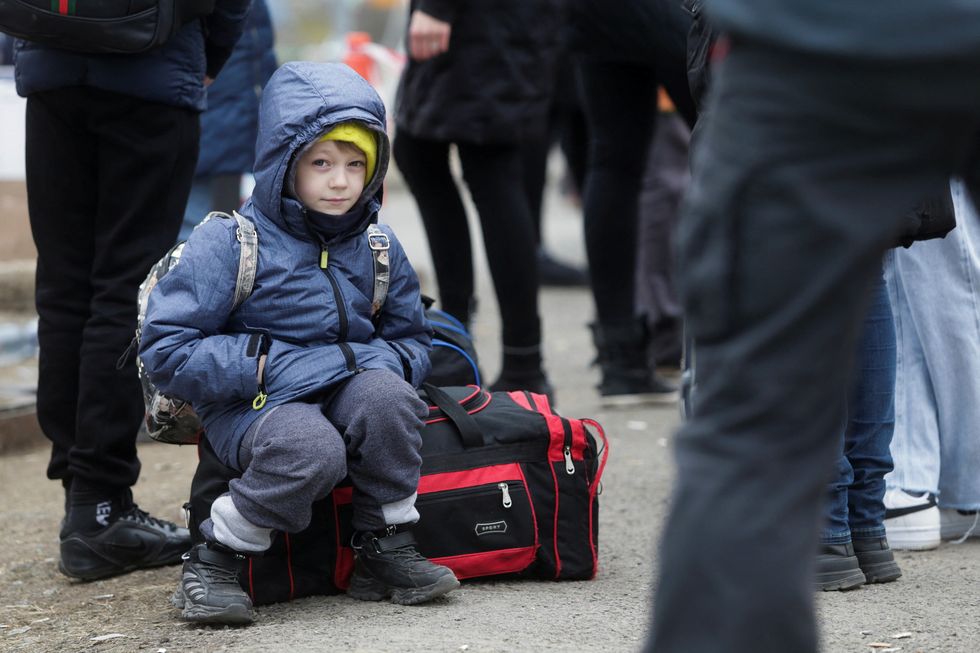 A boy looks on as refugees from Ukraine wait at the Ukrainian-Slovakian border after fleeing Russia's invasion of Ukraine, in Vysne Nemecke, Slovakia, March 5, 2022. REUTERS/Lukasz Glowala