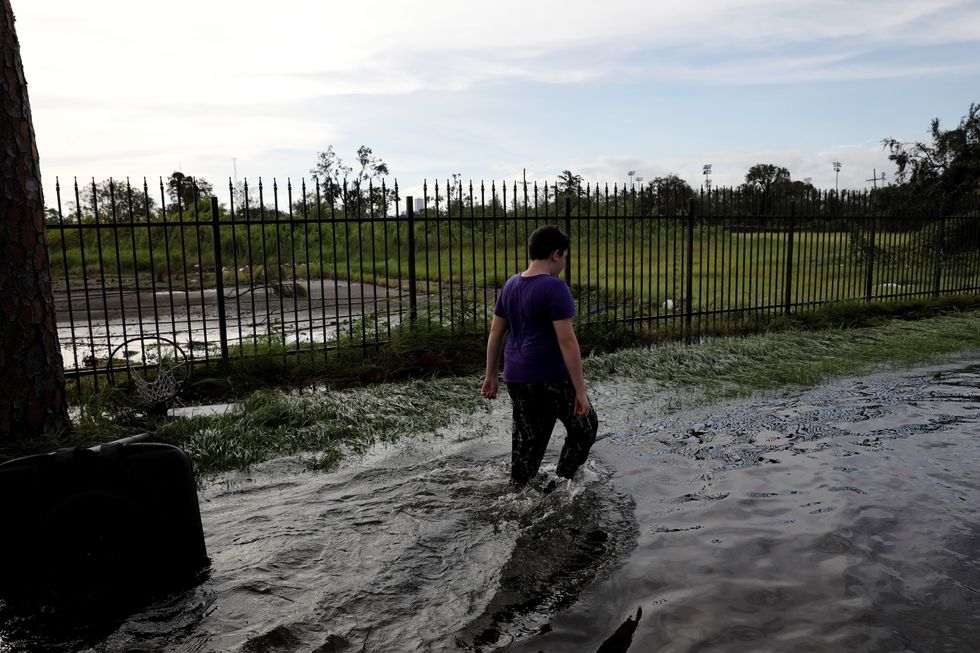 A boy walks in a flooded street after Hurricane Ida made landfall in Louisiana.