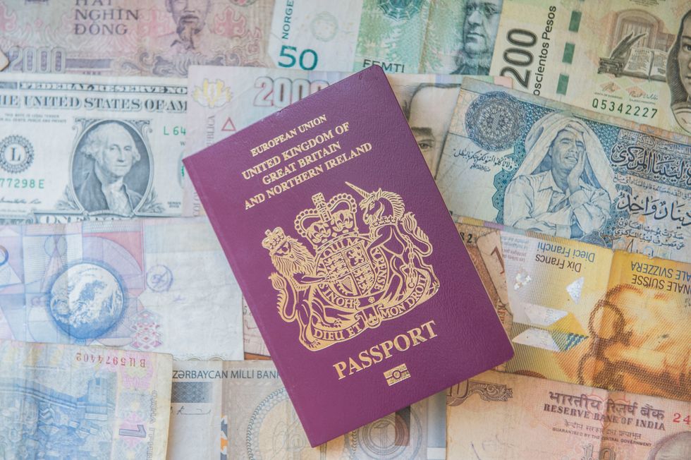 A British passport (United Kingdom of Great Britain and Northern Ireland), shown beside foreign bank notes, London.