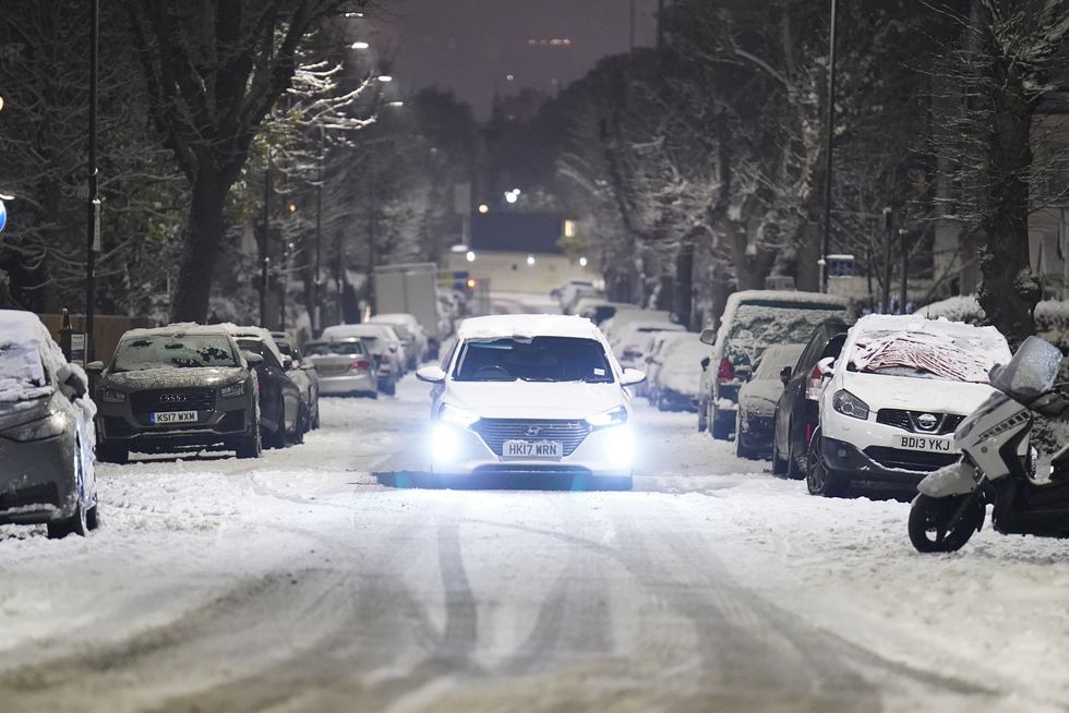 A car drives slowly along a snow covered road in the early morning at Willesden Green, north west London. Snow and ice have swept across parts of the UK, with cold wintry conditions set to continue for days. Picture date: Monday December 12, 2022.