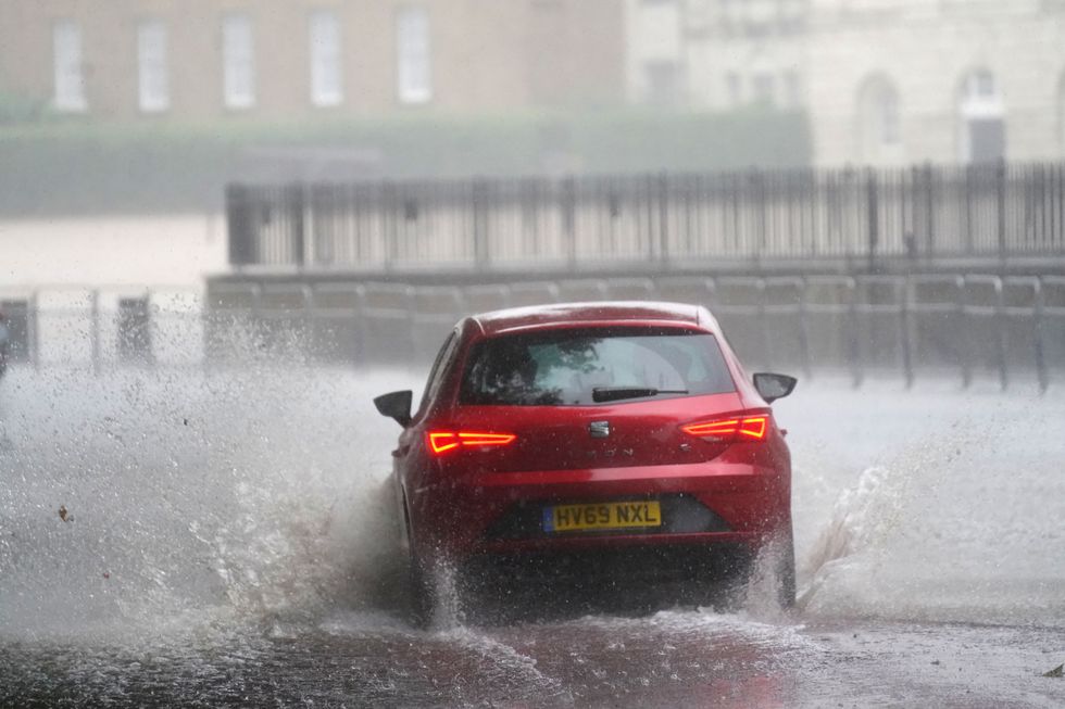 A car drives through flood water in Horse Guards Road in central London.