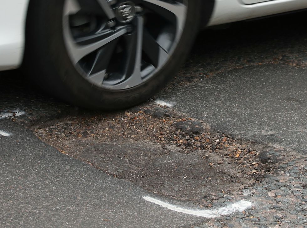 A car driving over a pothole.