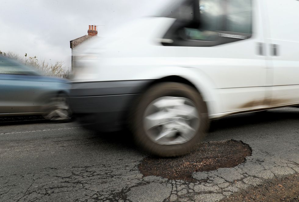 A car driving over a pothole.
