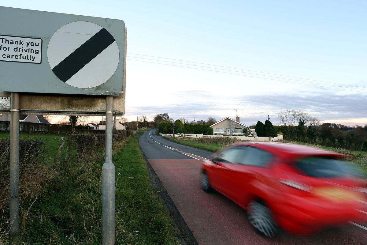 A car driving past a national speed limit sign