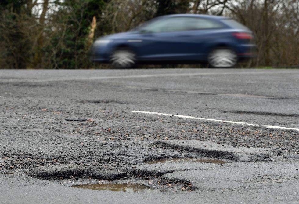 A car passing potholes in a road near Peterborough