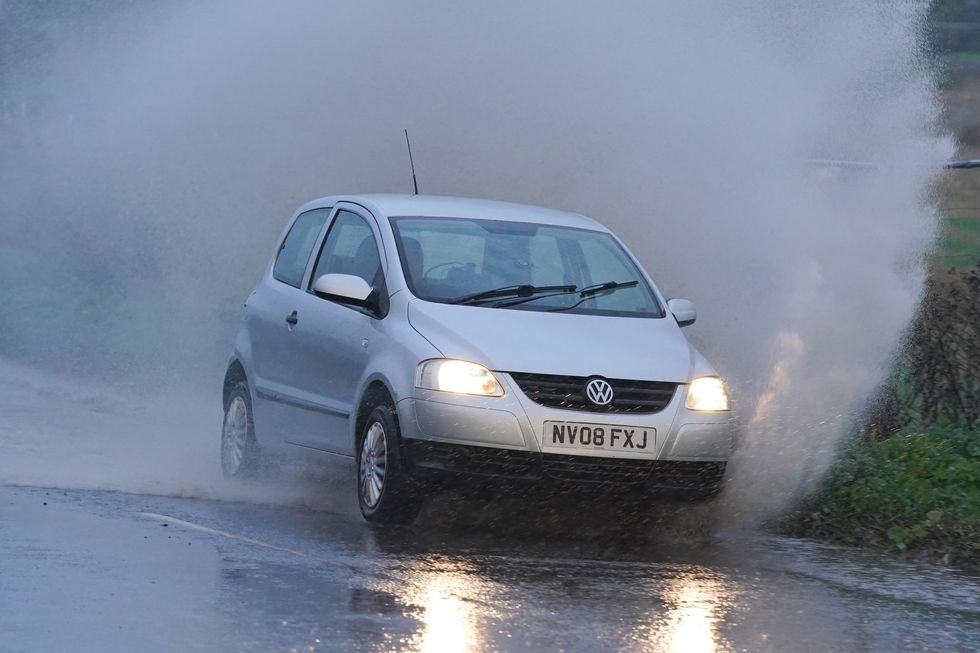 A car splashes through water in Manston, Kent. A yellow weather warning of heavy rain causing potential flooding to homes is in place for large parts of south-east England, with rain predicted for much of the coming week. Picture date: Sunday November 6, 2022.