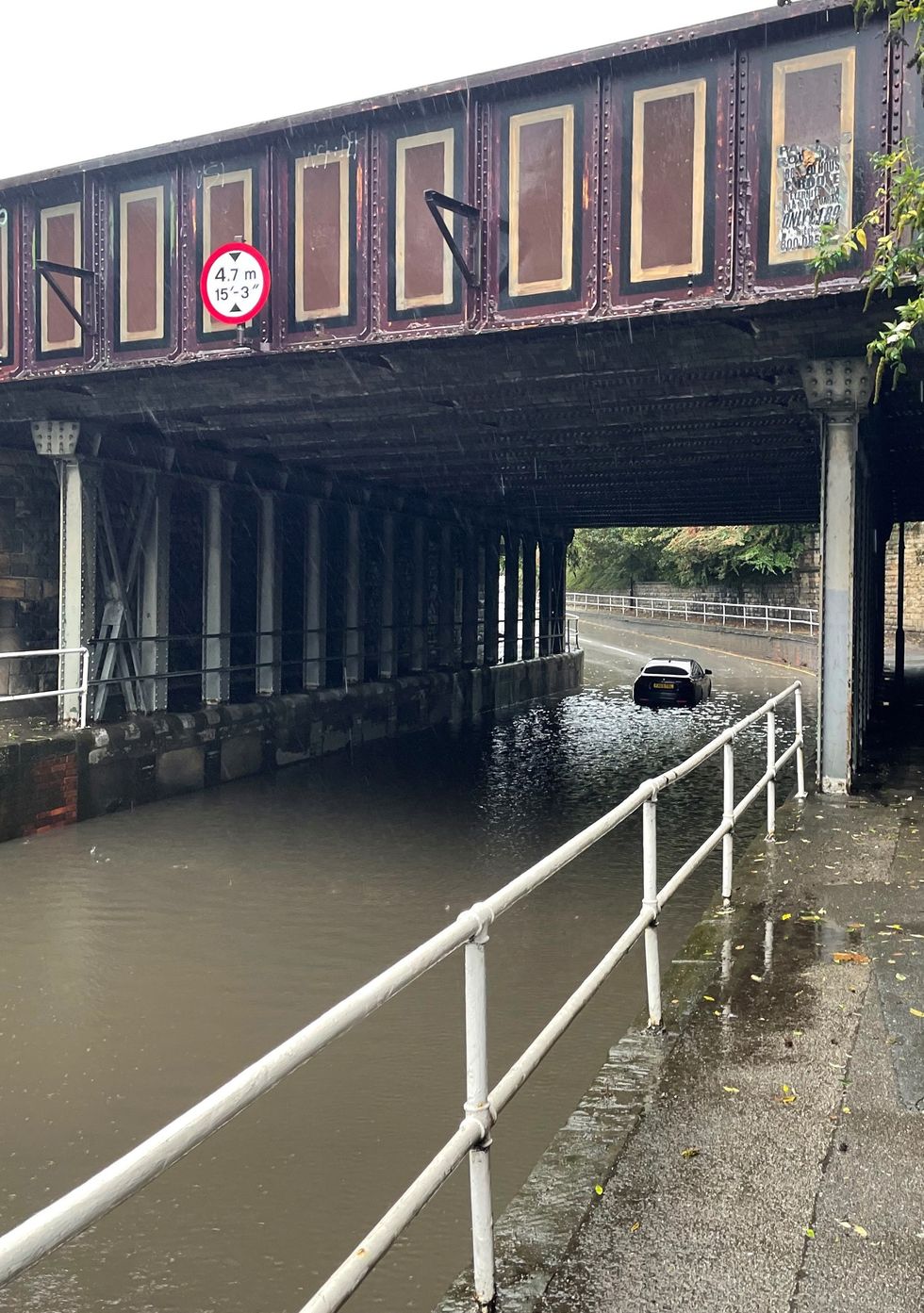 A car stuck in floodwater under a railway bridge at Upwell Street, Sheffield