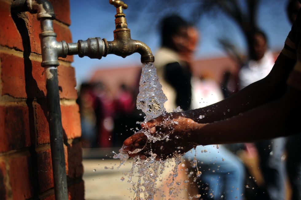 A child washes their hands as orphaned and vulnerable children attend a project run by Save The Children