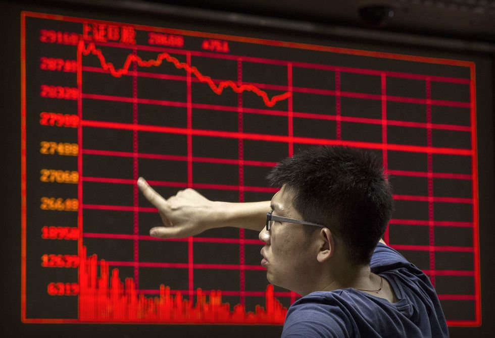 A Chinese day trader reacts as he watches a stock ticker at a local brokerage house