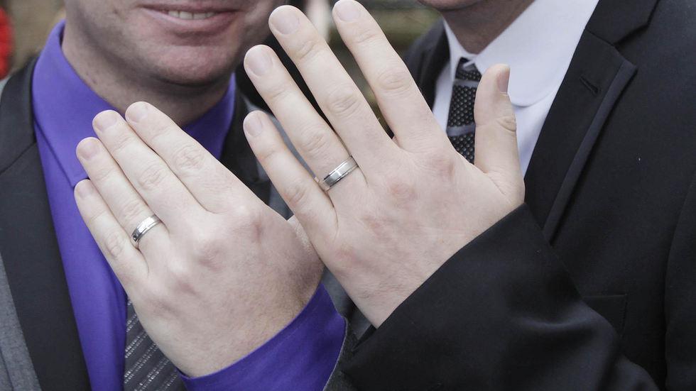 A civil partnered couple showing off their rings