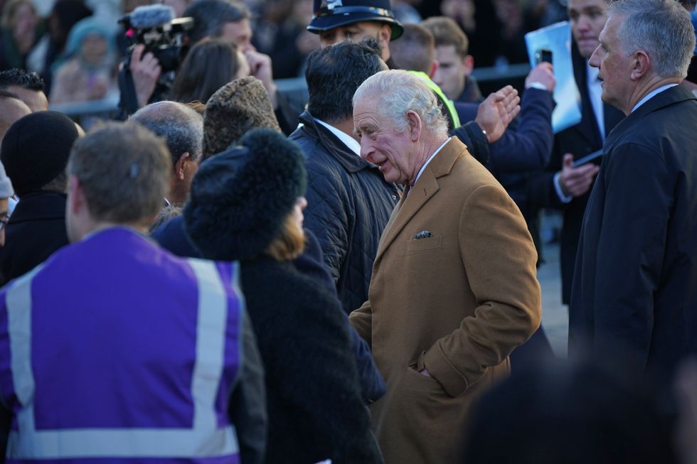 A close-protection officer (right) watches the crowd as King Charles III meets members of the public during a visit to Luton. A man in his 20s has been arrested on suspicion of common assault during a walkabout by the King in Luton town centre after an egg is believed to have been thrown in the direction of the monarch. Picture date: Tuesday December 6, 2022.