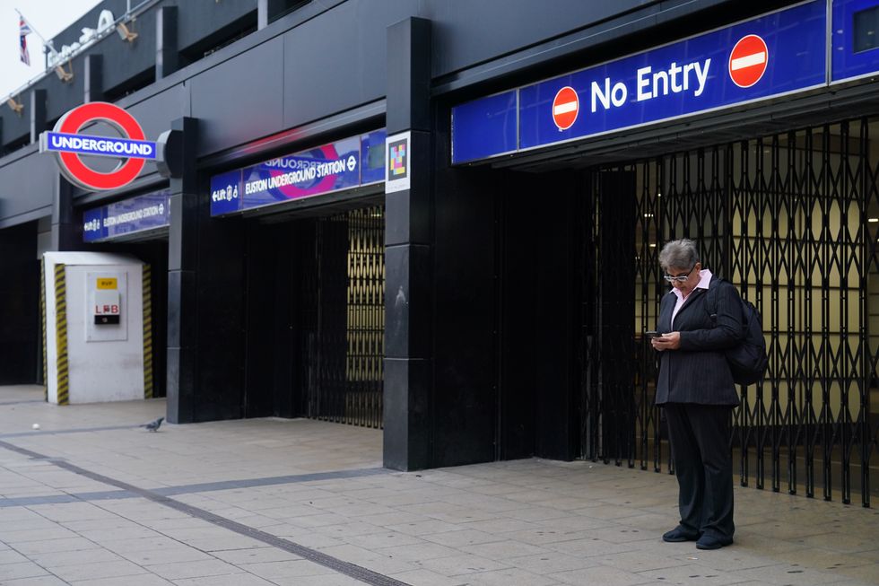 A commuter stands by the closed shutters at the entrance to Euston underground station in central London during a strike by members of the Rail, Maritime and Transport union (RMT) and Unite, in a long-running dispute over jobs and pensions. The strike by transport workers in London is expected to cause travel chaos with limited services on the Tube. Picture date: Thursday November 10, 2022.