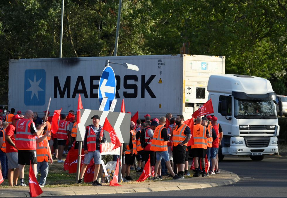 A container lorry passes strikers as it arrives at an entrance to the UK's biggest container port Felixstowe, as workers continue an 8-day strike, in Felixstowe, Britain, August 22, 2022. REUTERS/Toby Melville