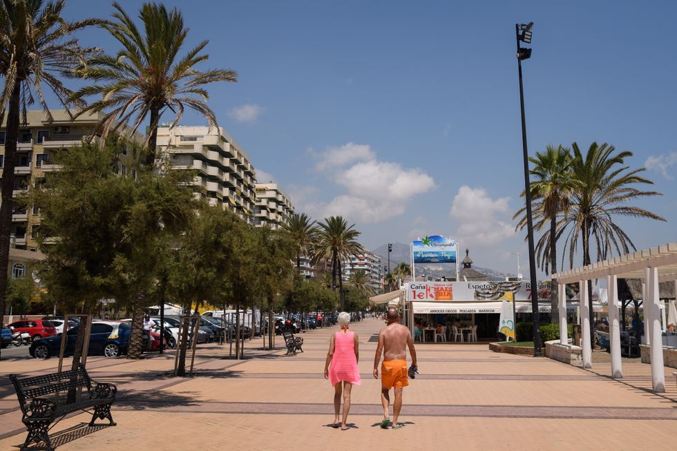 A couple walk along the beachside promenade