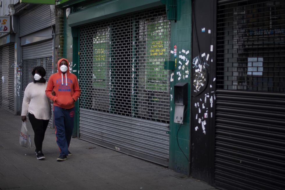 A couple wearing protective face masks on a high street.