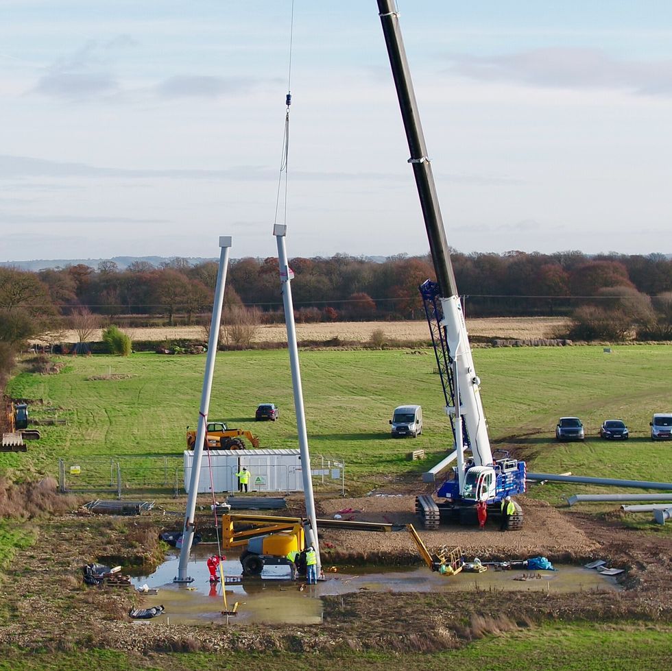 A crane moves steel podium into place