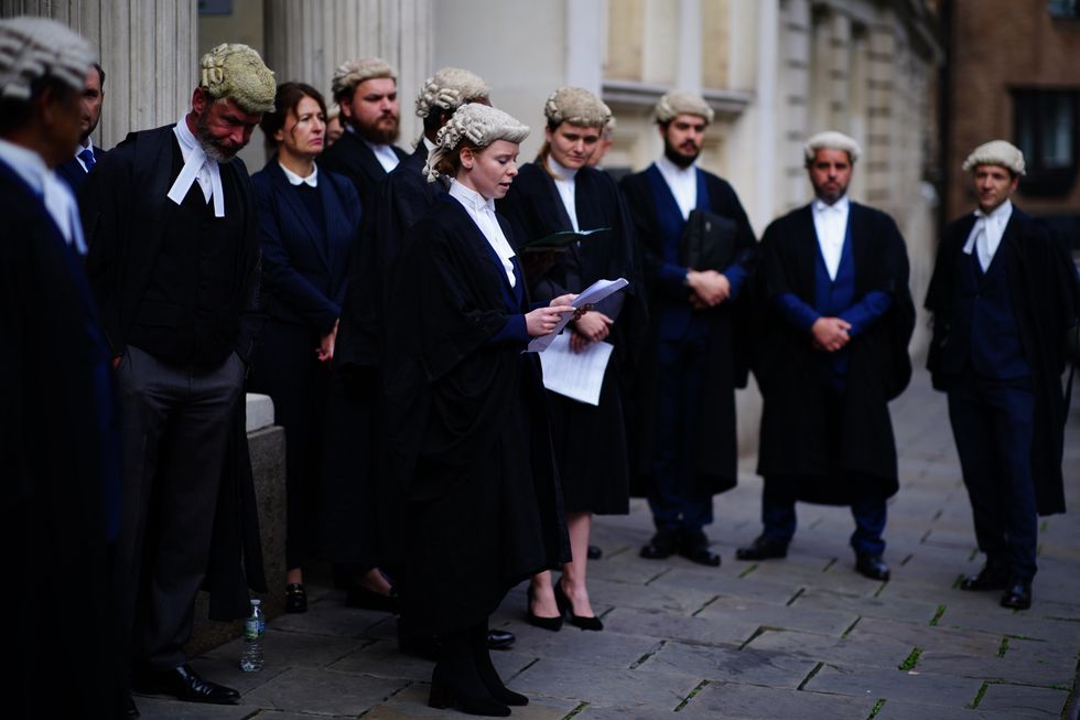 A criminal defence barrister reads a statement outside Bristol Crown Court in support of strikes for the Criminal Bar Association (CBA) who are taking action over Government set fees for legal aid advocacy work. Picture date: Tuesday September 6, 2022.