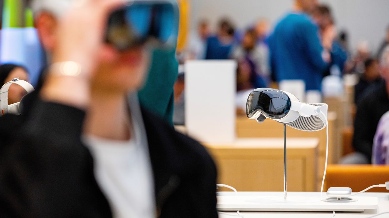 a customer adjusts the apple vision pro on their forehead in an apple store
