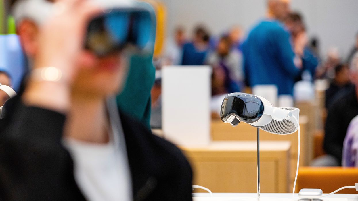 a customer adjusts the apple vision pro on their forehead in an apple store