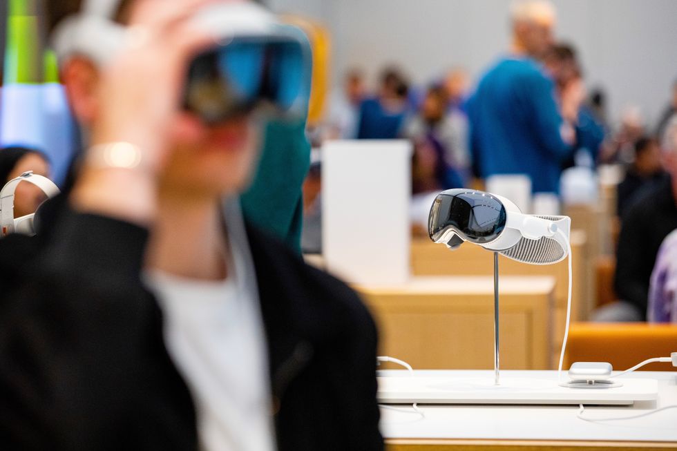 a customer adjusts the apple vision pro on their forehead in an apple store