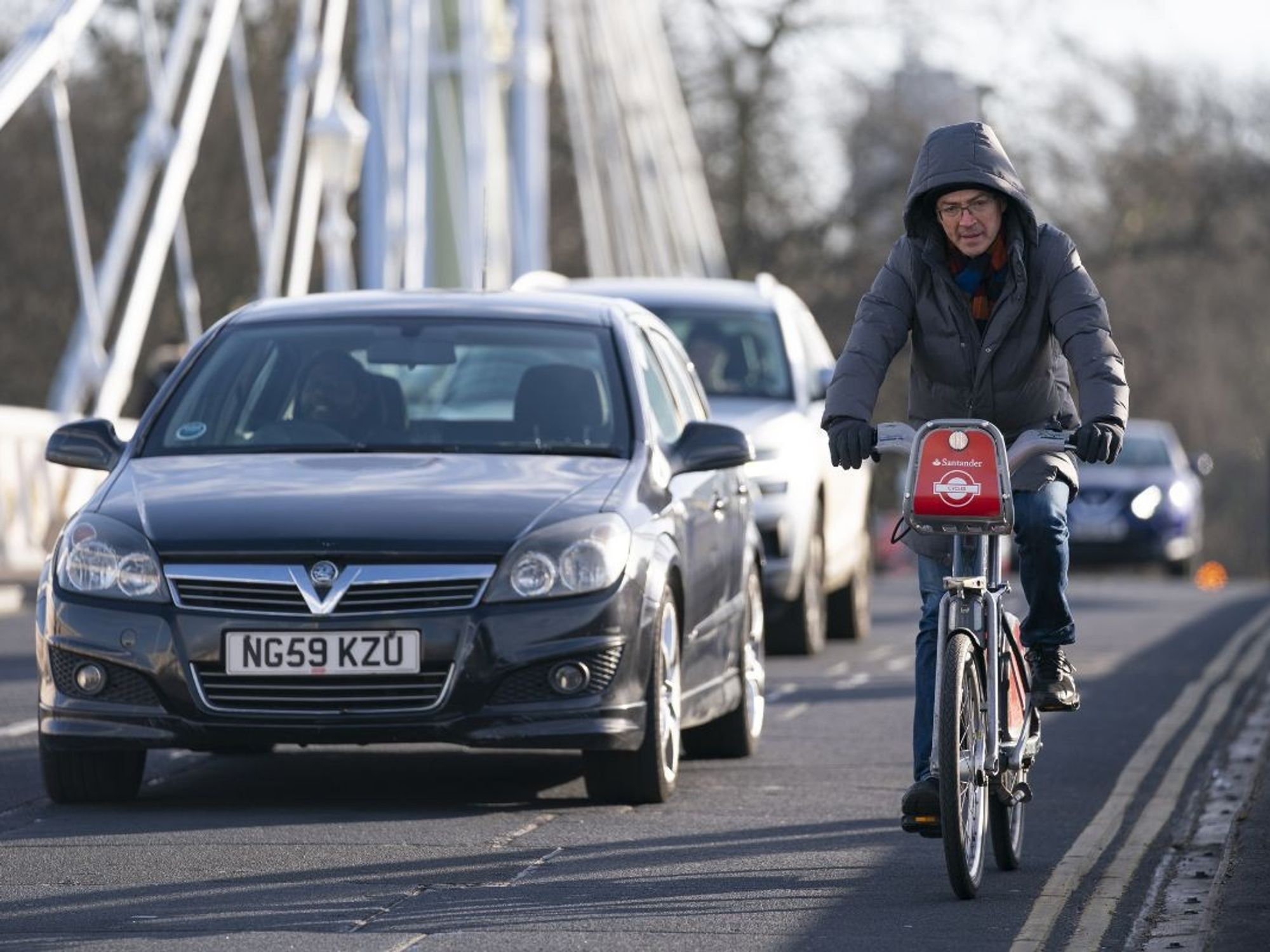 A cyclist riding along a car