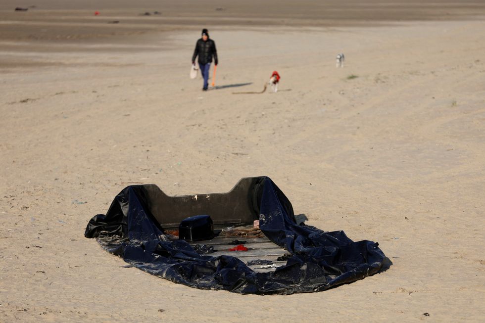 A damaged inflatable dinghy lies on the beach in Gravelines, one of the beaches used by migrants to leave by small dinghies the coast of northern France to cross the English Channel in an attempt to reach Britain, near Calais, France, December 14, 2022.