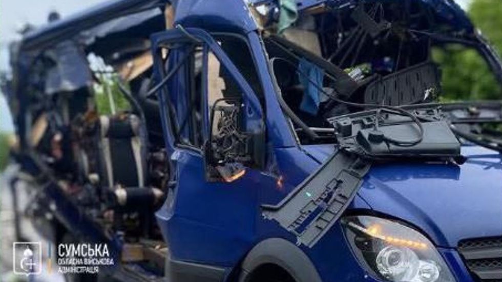 A dark blue passenger van nearly destroyed