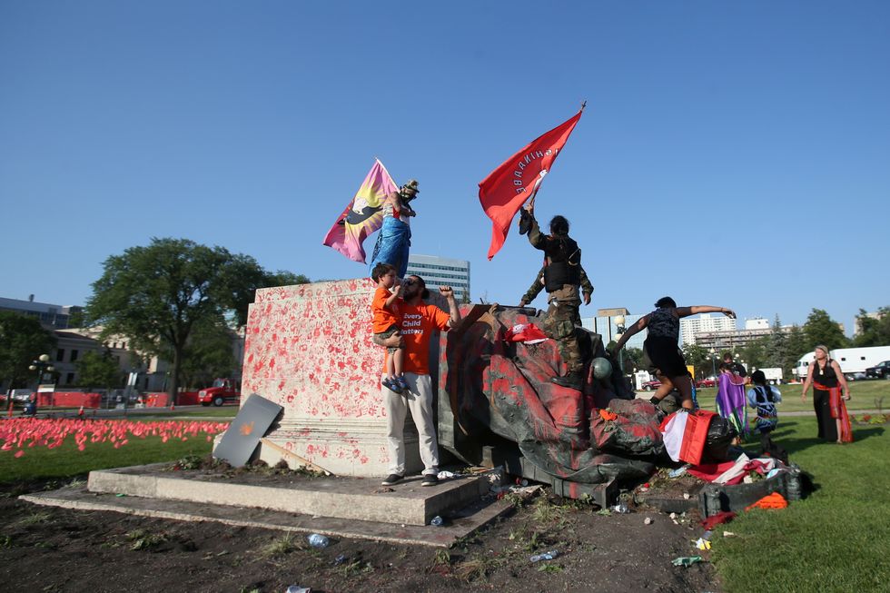 A defaced statue of Queen Victoria lies after being toppled during a rally, following the discovery of the remains of hundreds of children at former indigenous residential schools, outside the provincial legislature on Canada Day in Winnipeg.