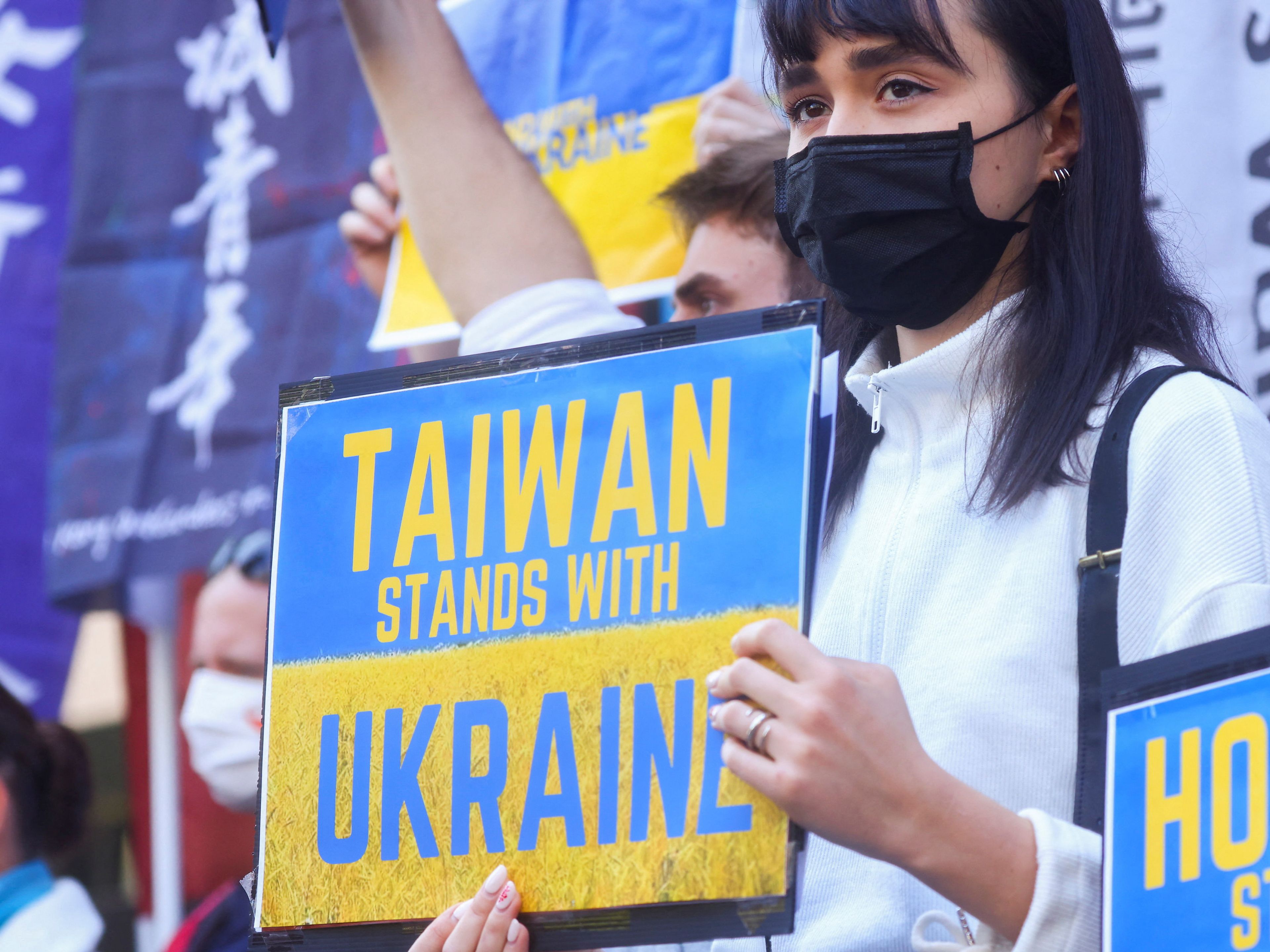 A demonstrator holds a placard during a rally against Russia's invasion of Ukraine outside a Moscow representative office in Taipei, Taiwan.