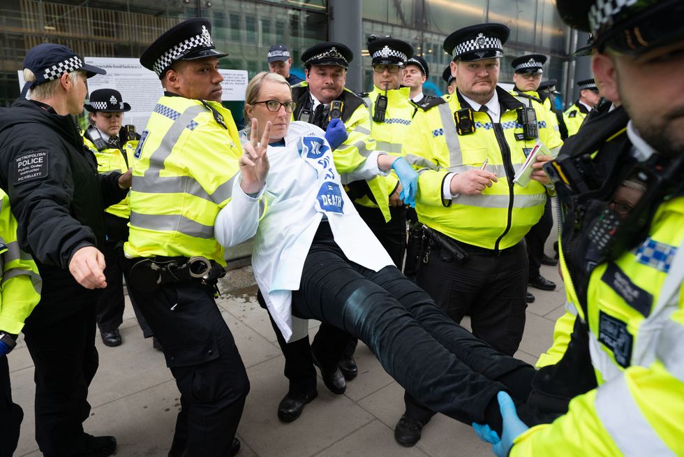 A demonstrator is carried away by police outside the Department for Business in London after protesting against oil and gas production. Picture date: Wednesday April 13, 2022.