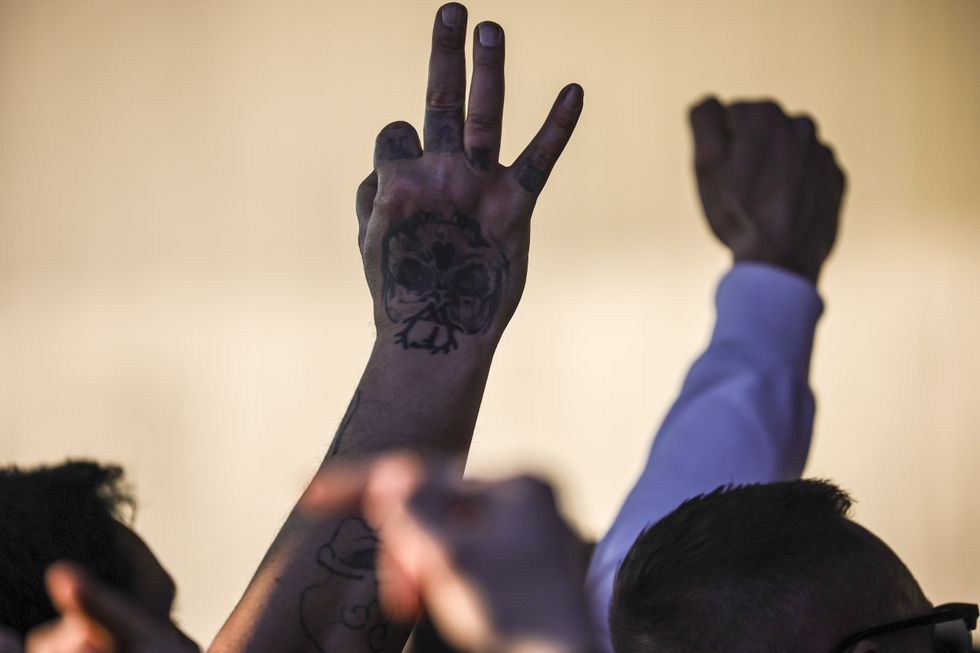A demonstrator raises the 'WP' hand gesture at a rally in Berlin