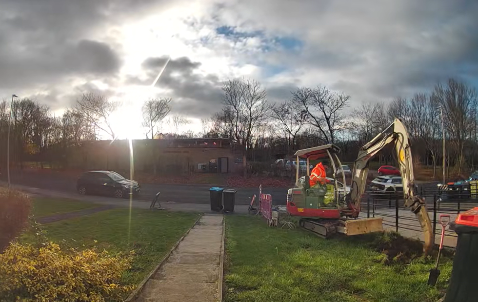 A digger rips up turf on Melanie Abbott's lawn