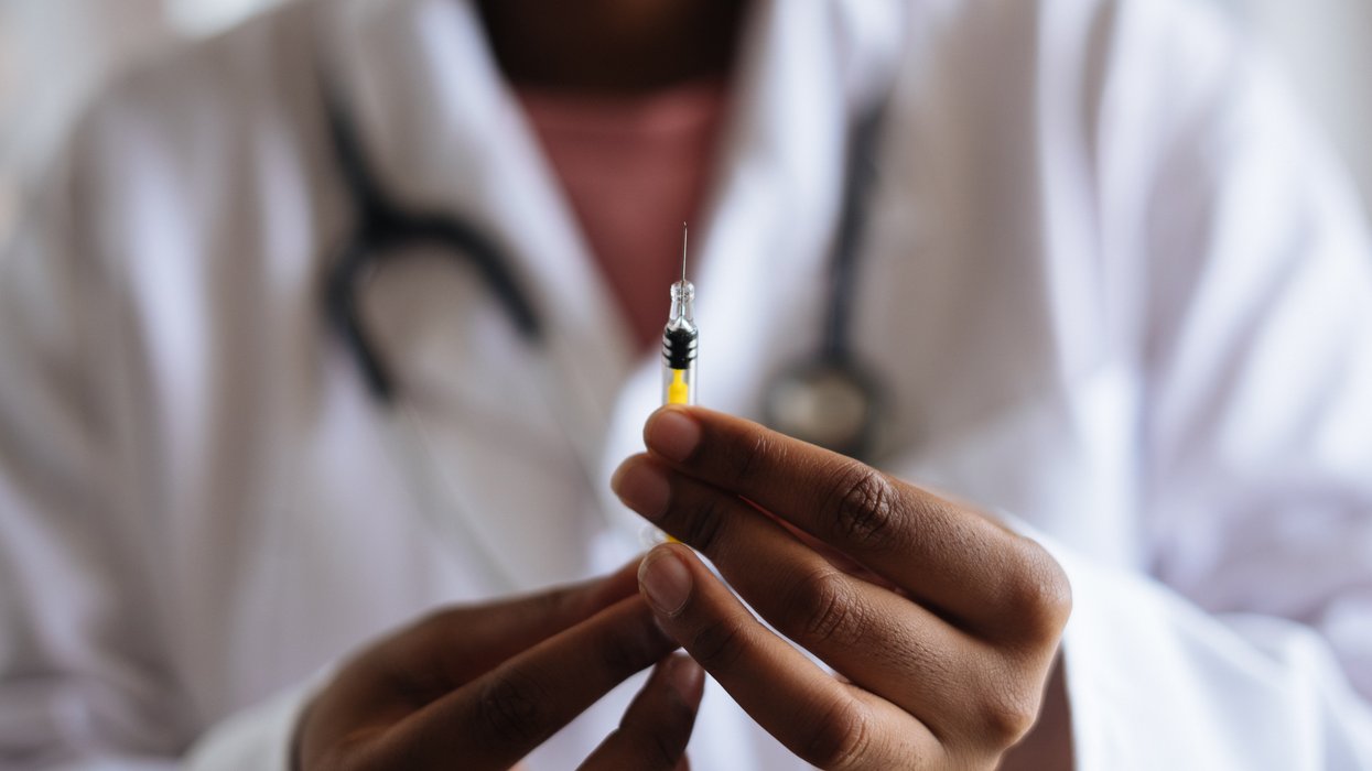 A doctor holds a needle