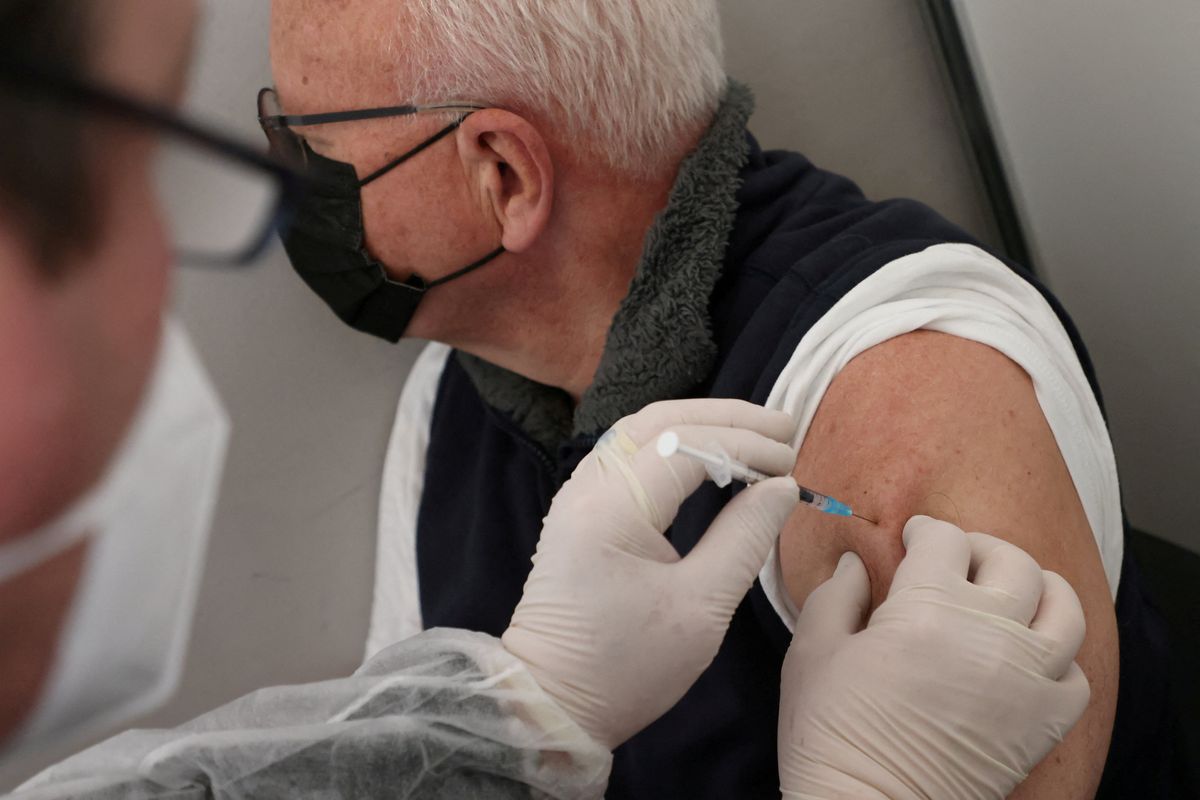 A doctor vaccinates a man with Comirnaty Pfizer BioNTech coronavirus disease (COVID-19) vaccine in Berlin