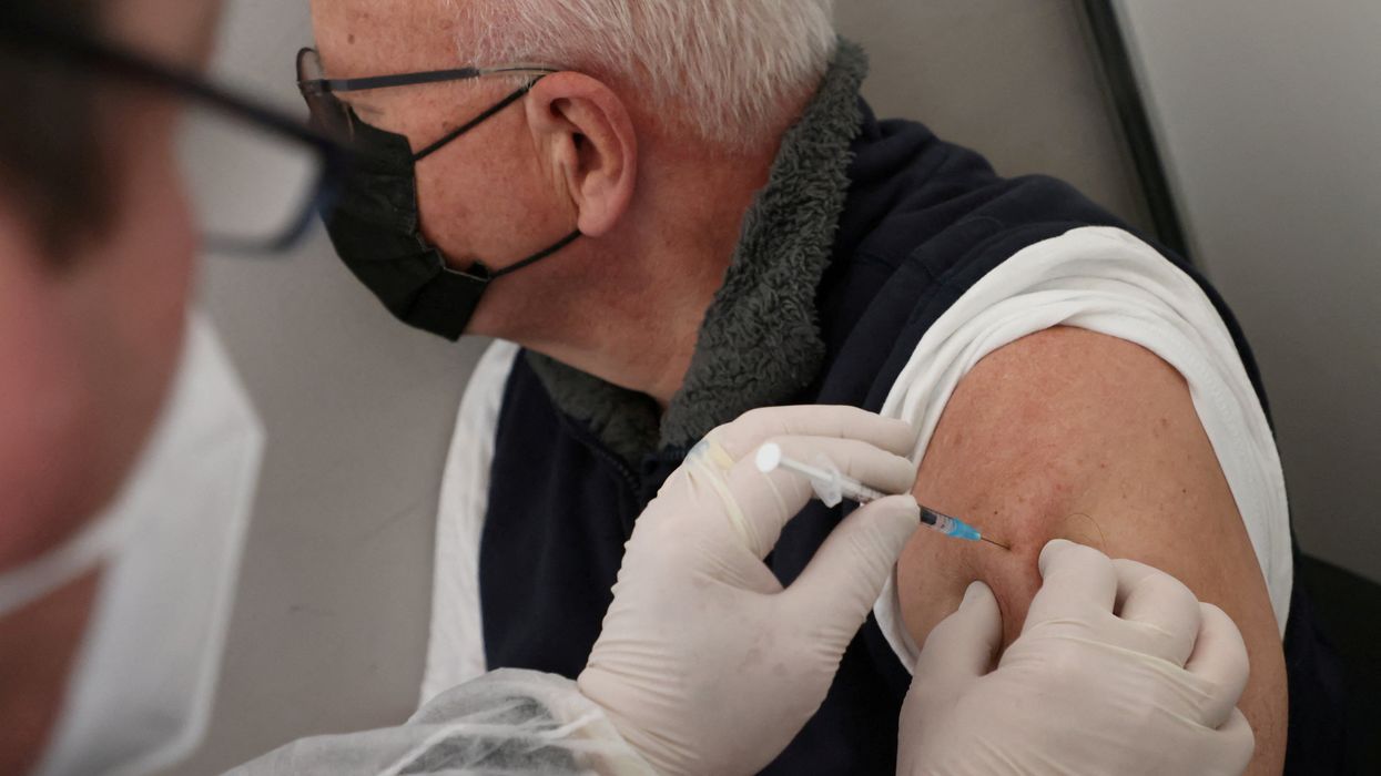 A doctor vaccinates a man with Comirnaty Pfizer BioNTech coronavirus disease (COVID-19) vaccine in Berlin