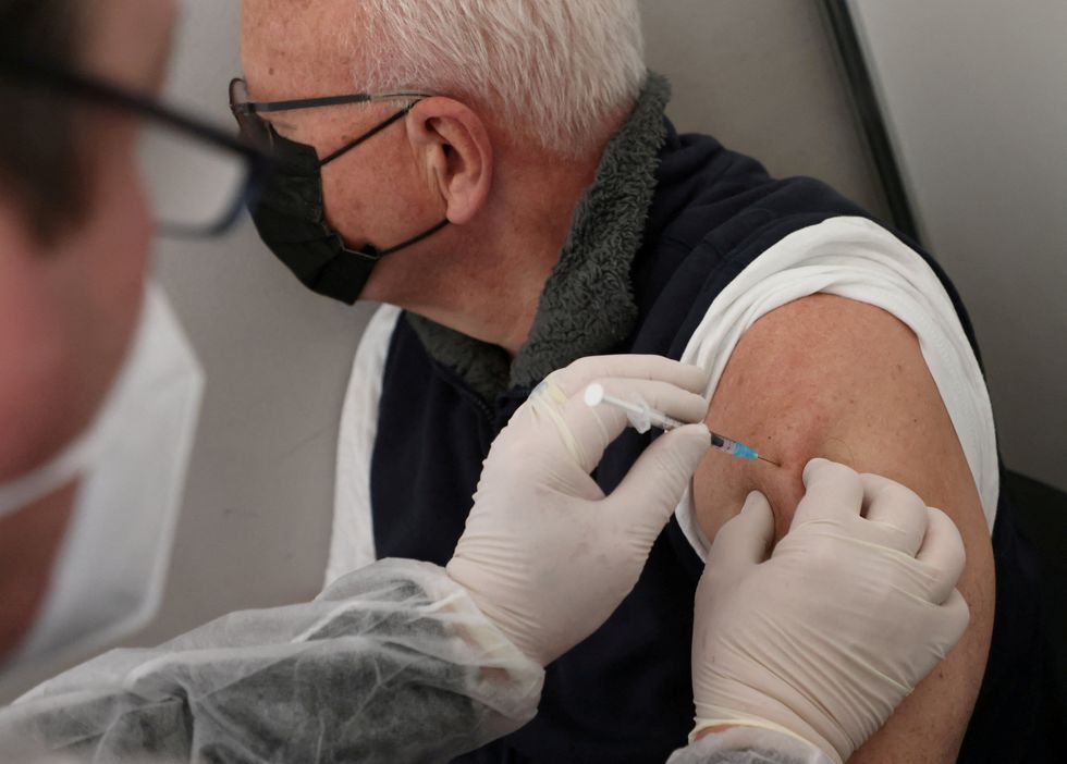 A doctor vaccinates a man with Comirnaty Pfizer BioNTech coronavirus disease (COVID-19) vaccine in Berlin