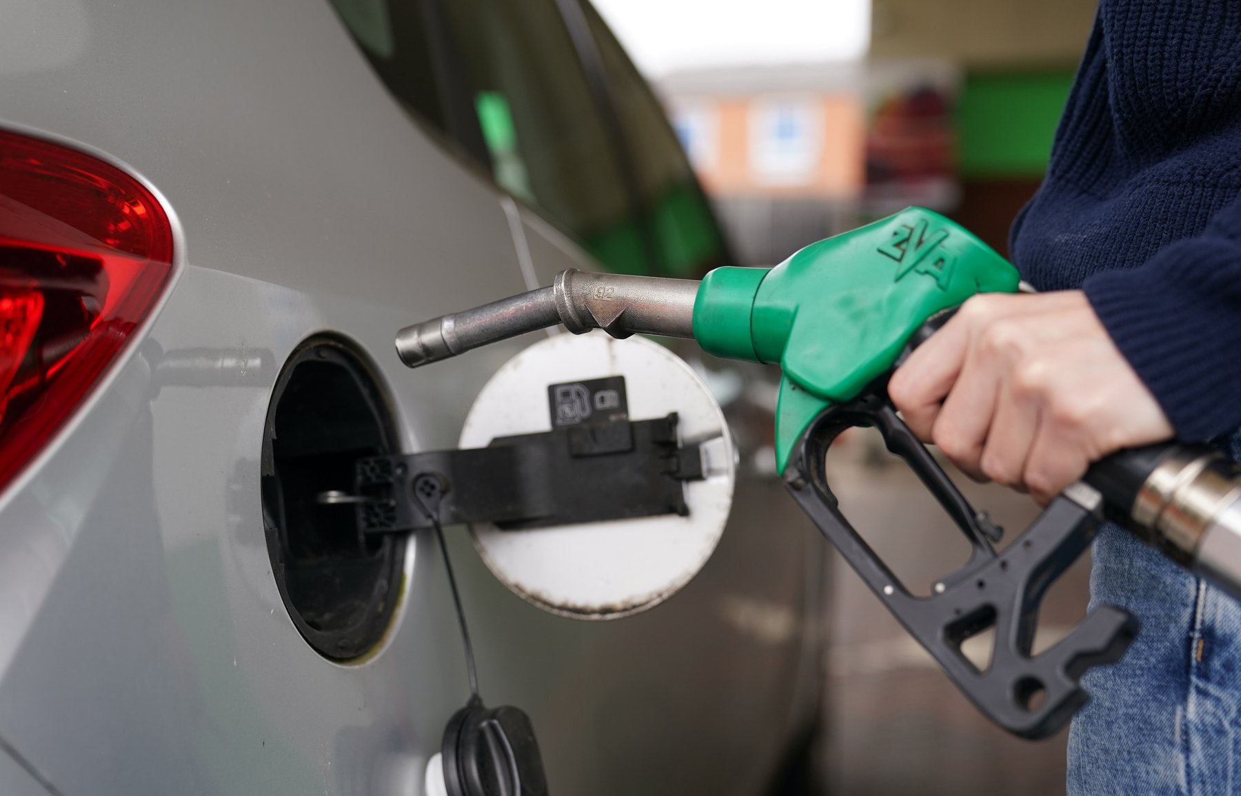 A driver holding a petrol pump.