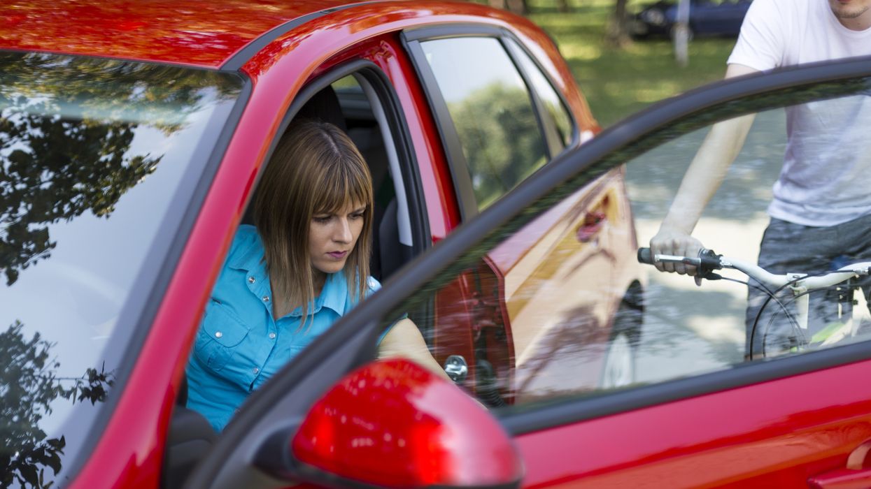 A driver opening a car door on a cyclist