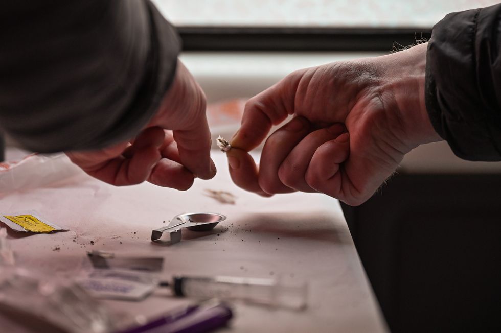 A drug user prepares heroin before injecting