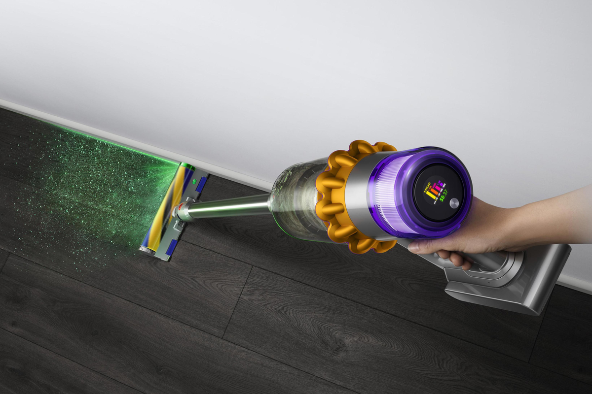 a dyson v15 detect in-use with the laser illuminating dust on the floor