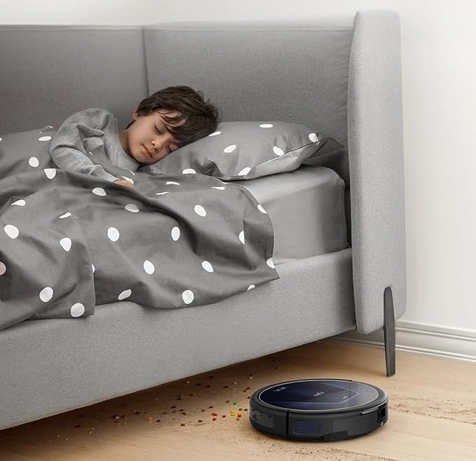 a eufy robot vacuum drives under the bed while someone sleeps above it