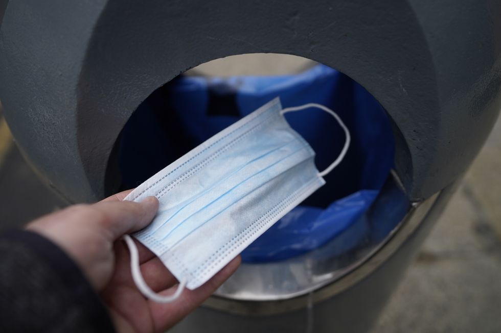 A face mask is thrown into a bin in Dublin, Ireland as mask-wearing is no longer mandatory in Ireland, and politicians hailed the day as a %22milestone%22 moment after two years of the coronavirus pandemic.. Picture date: Monday February 28, 2022.